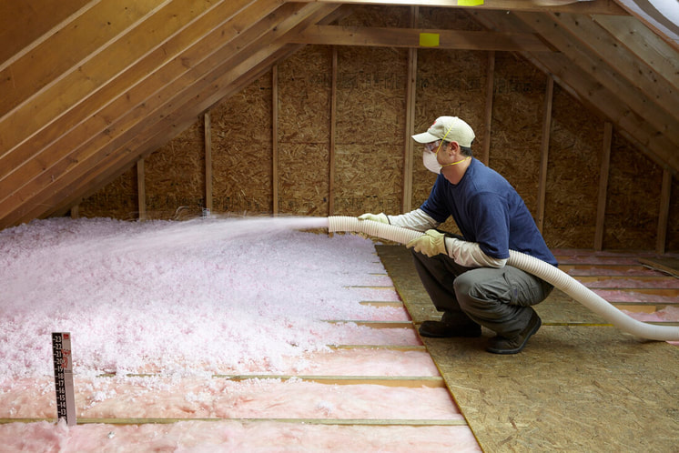 A worker doing fiberglass insulation.